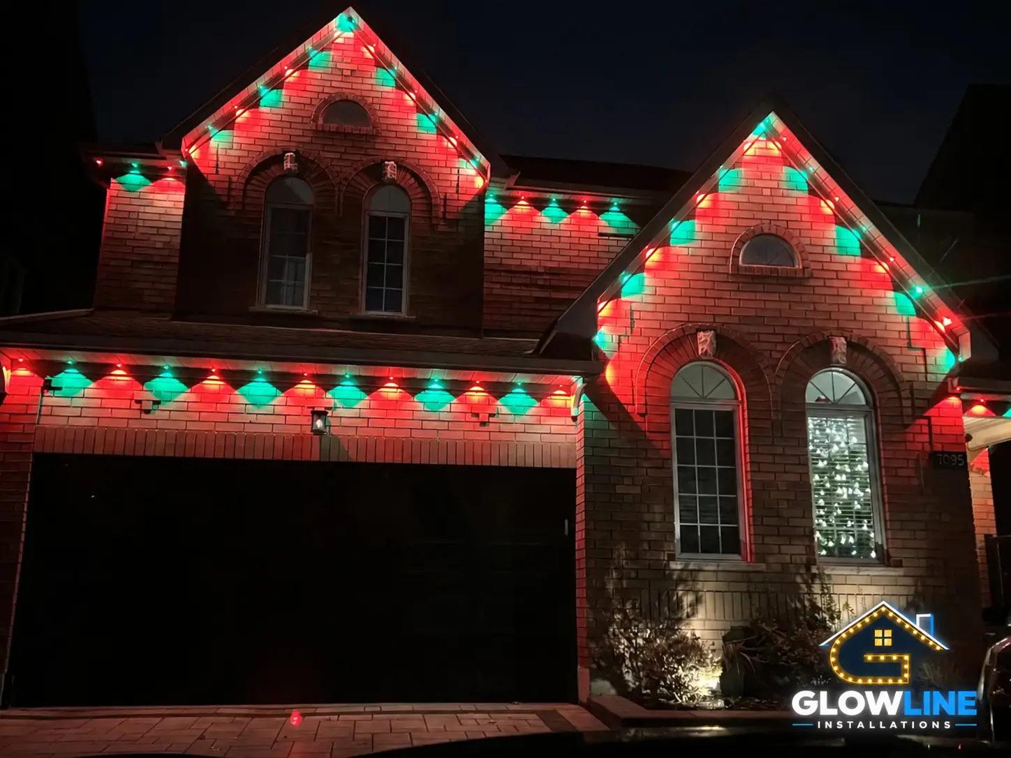 Christmas red and green outdoor lights on brick home