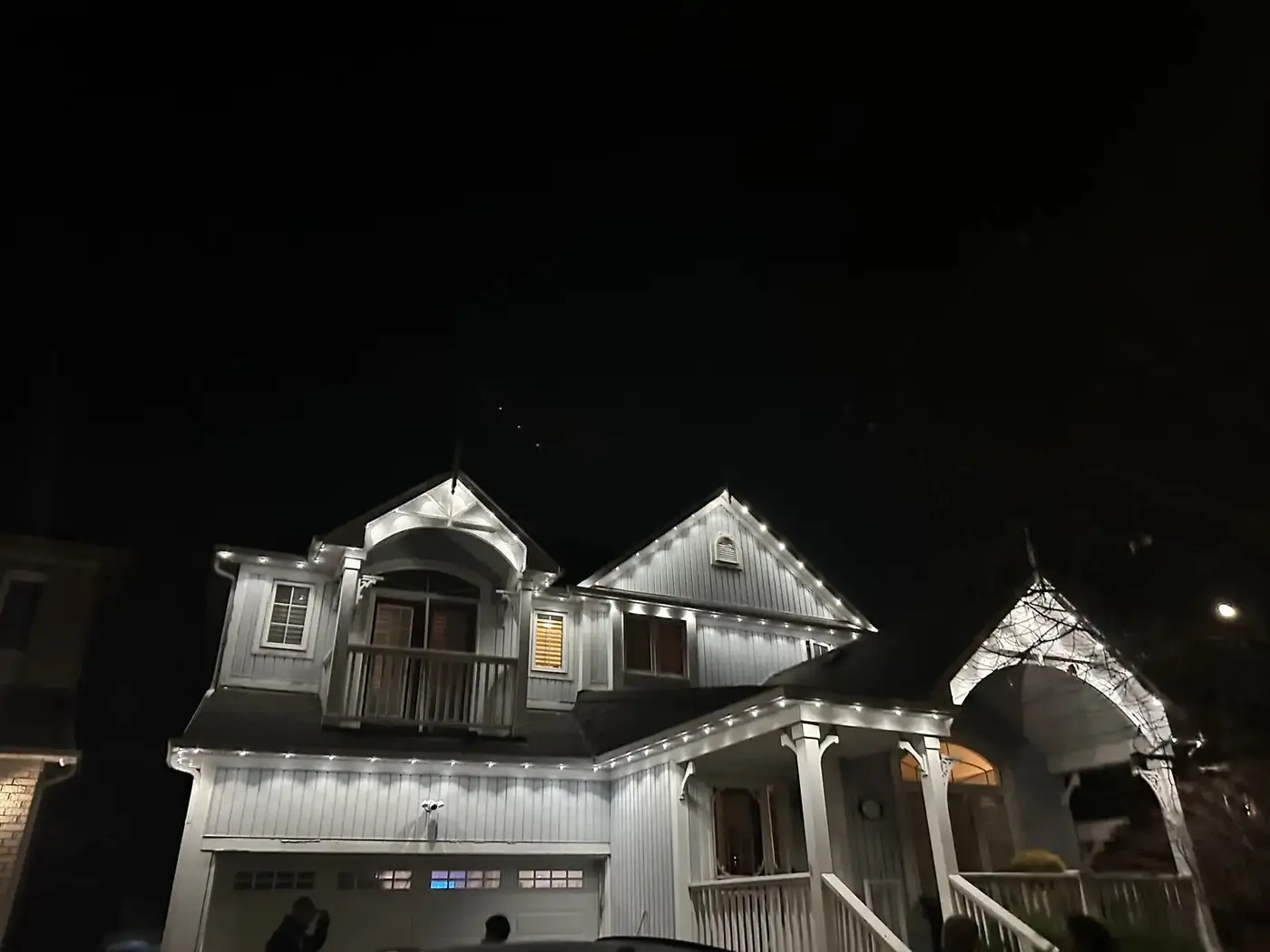 Warm white permanent outdoor lights installed along a roofline